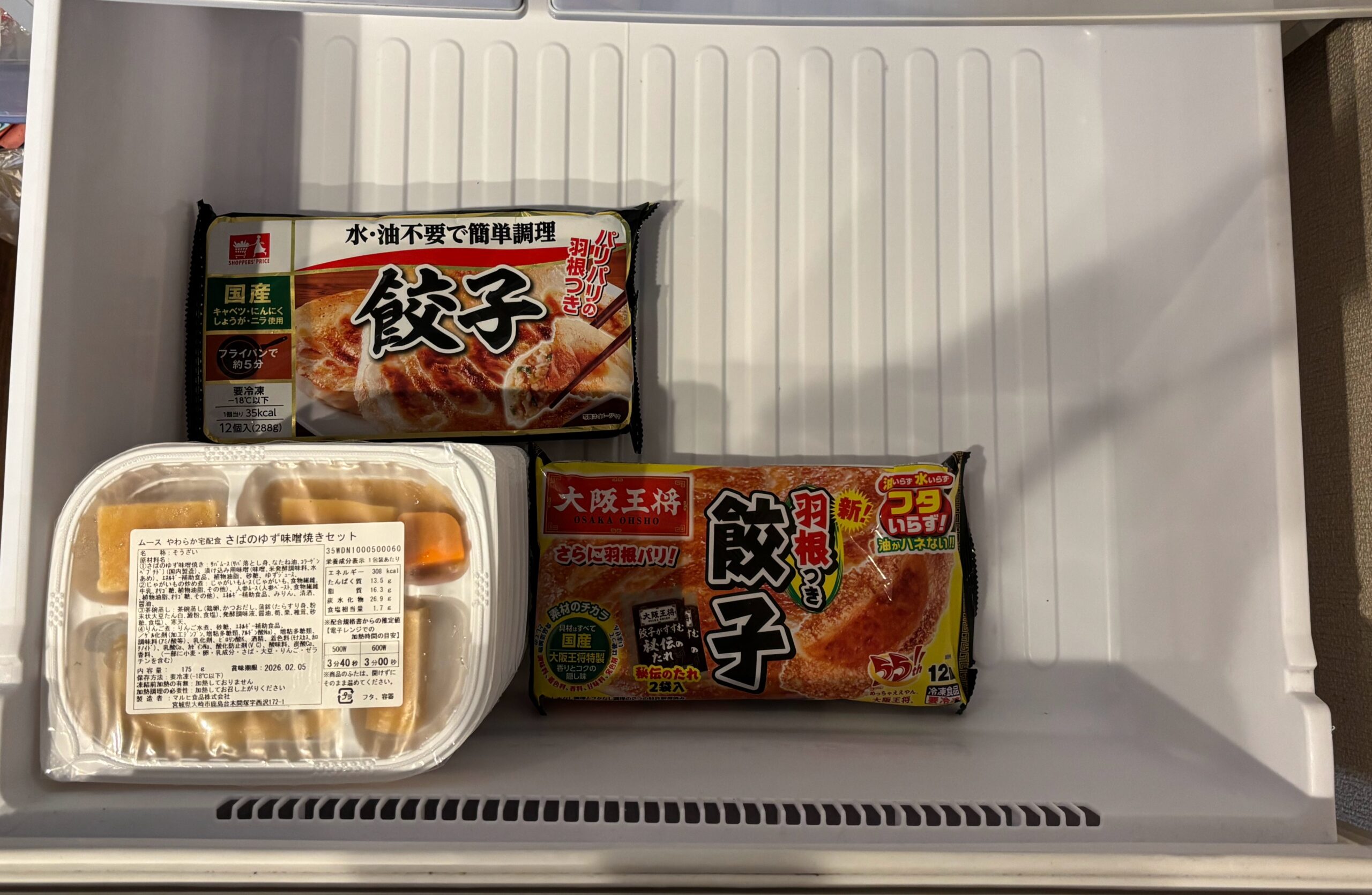 自宅の冷凍庫に、ムースやわらか宅配食を7セット積んでいれています。お弁当の上と横に冷凍餃子を置くことで、実際に入れた時の大きさがイメージ出来ます。