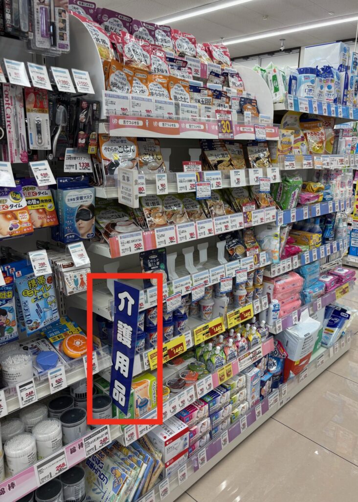 「介護用品」とかかれた看板に、介護食がたくさん並んでいる写真。