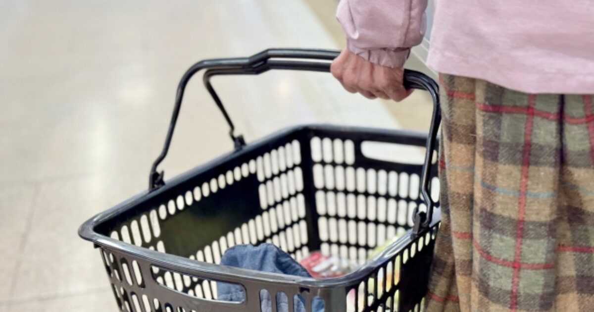 スーパーでムース食の売り場が見つからず悩む高齢女性の買い物シーン