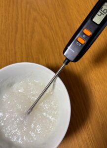 お粥ゼリーの温度を確認しているところ