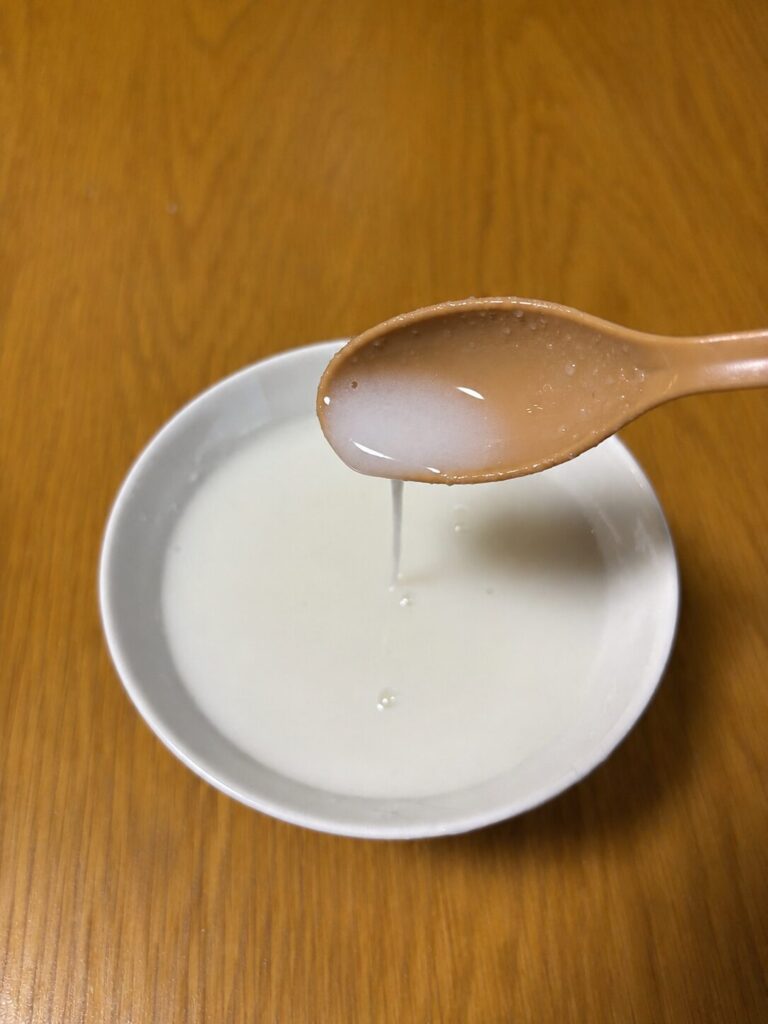 スプーンで液状化したお粥をすくっているところ