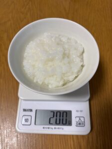 お茶碗に盛った全粥200g。重さを計っている写真
