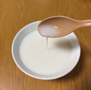 スプーンで液状化したお粥をすくっているところ