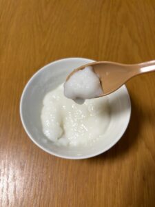 お茶碗に盛り付けたお粥ゼリーをスプーンですくっている写真。ぷるんとしたゼリー状に固まっていることが分かる。