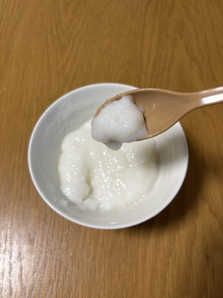 スプーンでやわらかいお粥ゼリーをすくっているところ