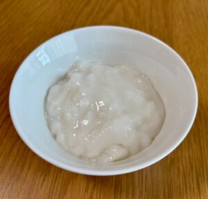 キユーピー「なめらかごはん」を白いお茶碗に盛り付けた写真。粒のないなめらかな白色で、透明感のあるとろとろした見た目
