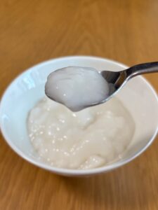 キユーピー「なめらかごはん」をスプーンですくった写真。常温の状態でとろーっとした柔らかい食感がわかる
