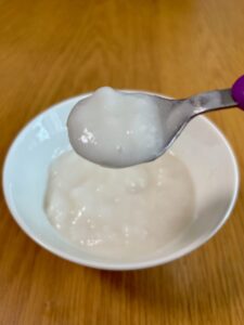 キユーピー「なめらかごはん」をレンジで温めた後、スプーンですくった写真