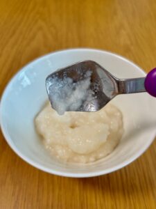 アサヒ「なめらかごはん」をスプーンですくい、傾けた状態。スプーンはあまり残っていない。