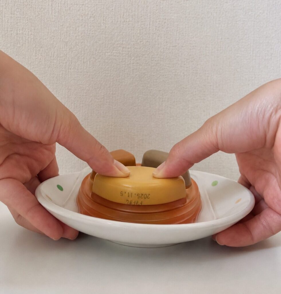 エバースマイル トマトソースオムレツを逆さまにして、両親指で押している写真