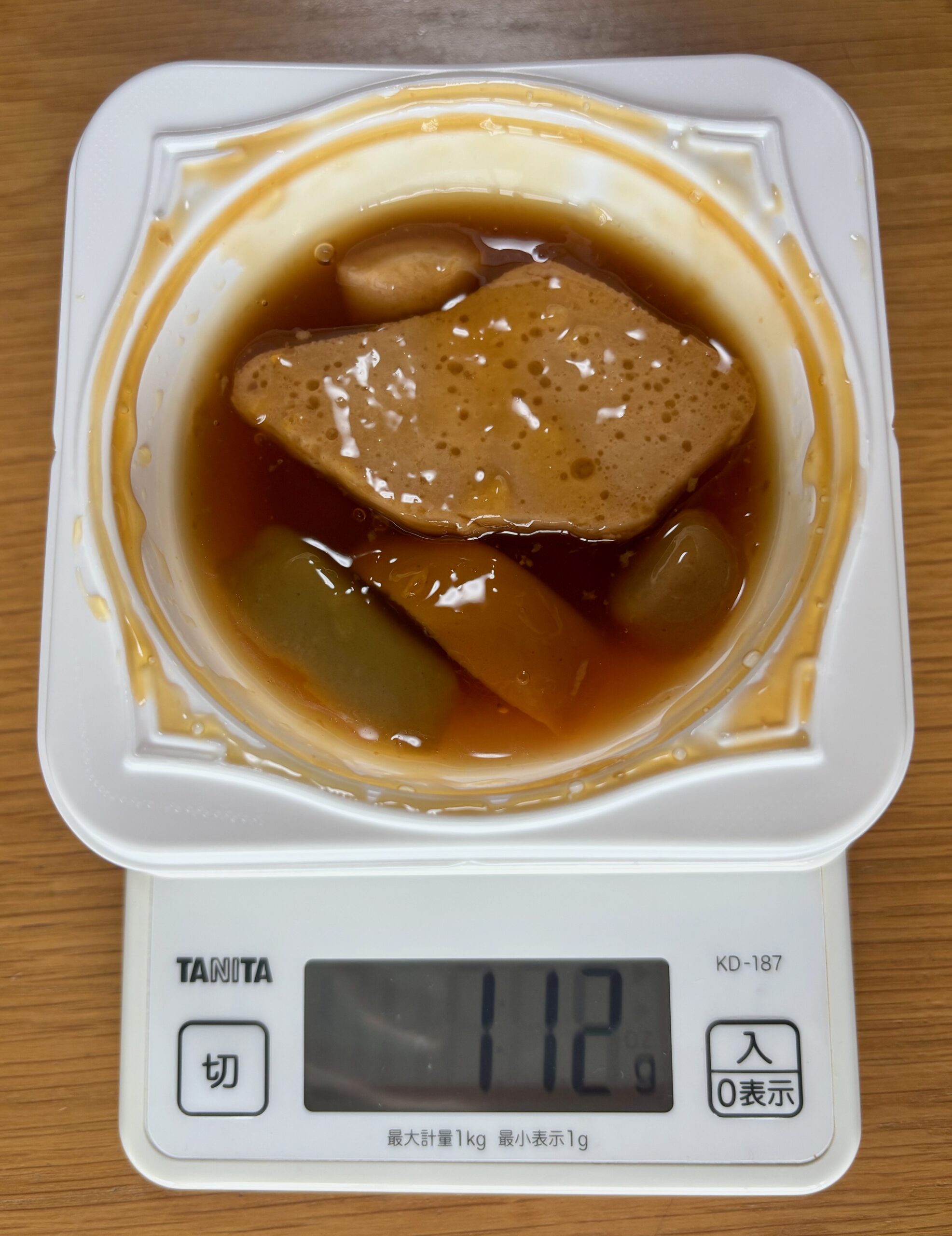 エバースマイル 白身魚の煮つけをキッチンスケールにのせた写真。112g（容器込み）。