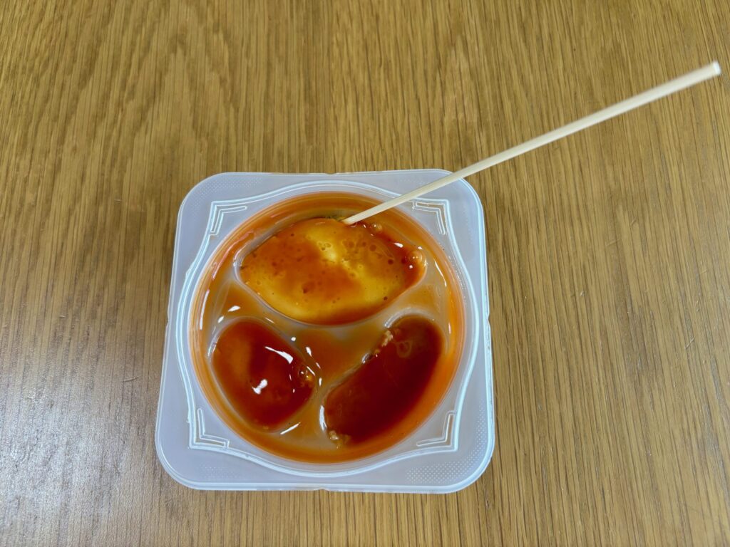 竹串でトマトソースオムレツと容器の間に隙間を作っている写真