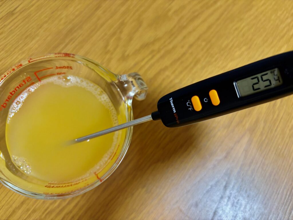 オレンジジュースの温度を調理用の温度計で測っている所。