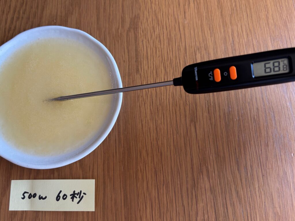 電子レンジで60秒加熱し、完全に溶けて68.8度になったオレンジムースゼリーと温度計