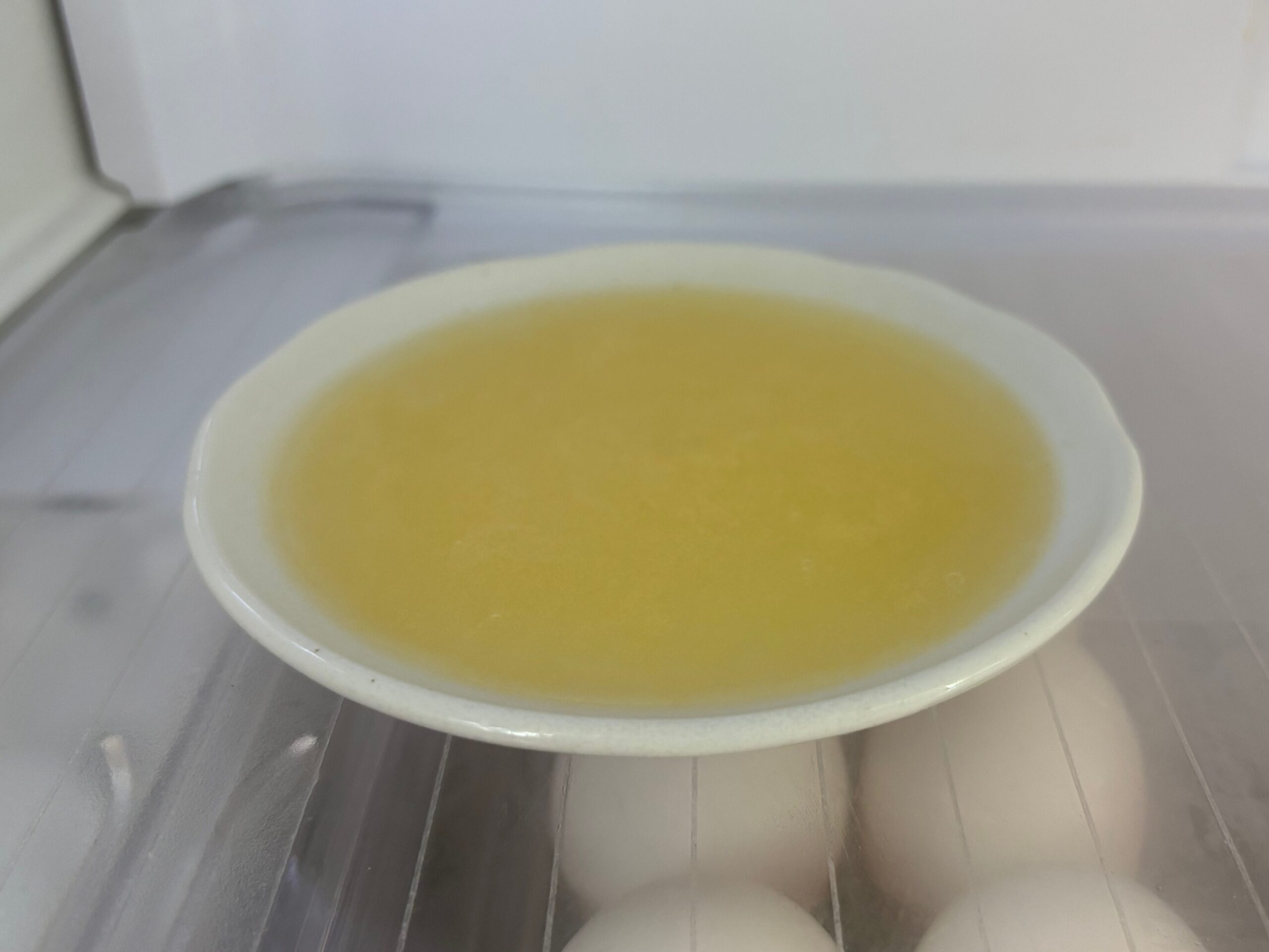 電子レンジで完全に溶けて液体になったオレンジムースを冷蔵庫で冷やし始めた写真