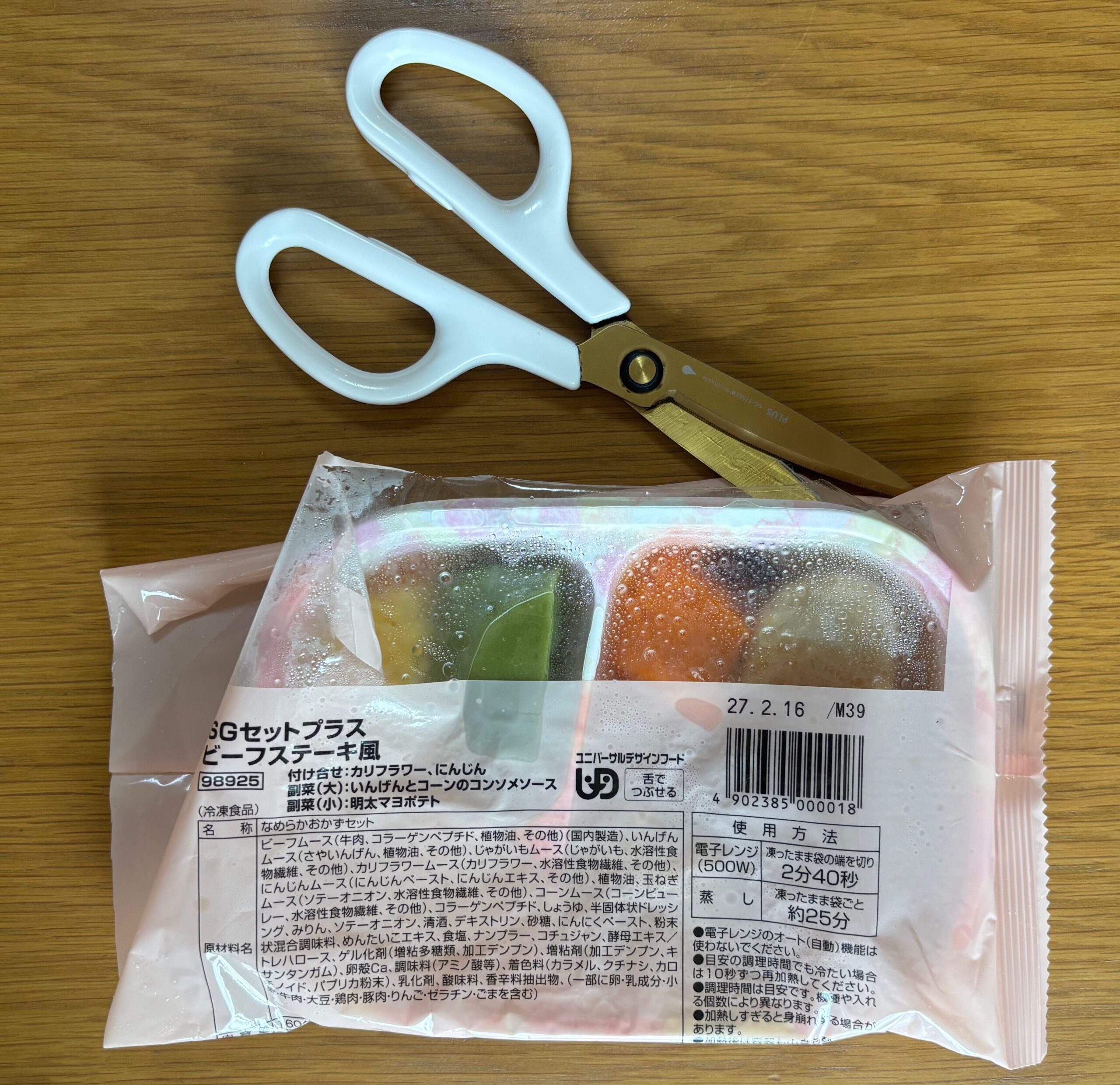温めた後の食楽膳の袋が熱いため、ハサミでパッケージを切って開けている写真
