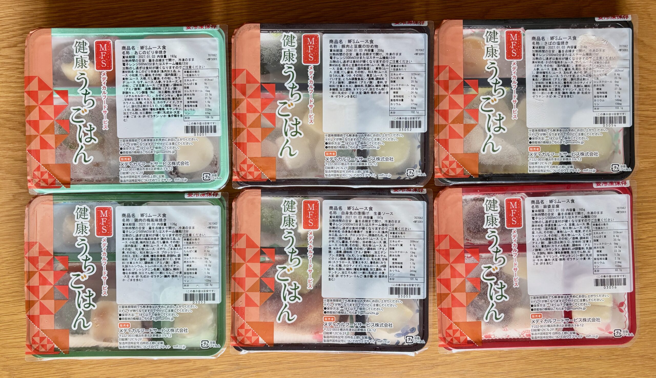 MFSのムース食6食を机に並べた写真。容器の色が緑・赤・黒と色とりどり