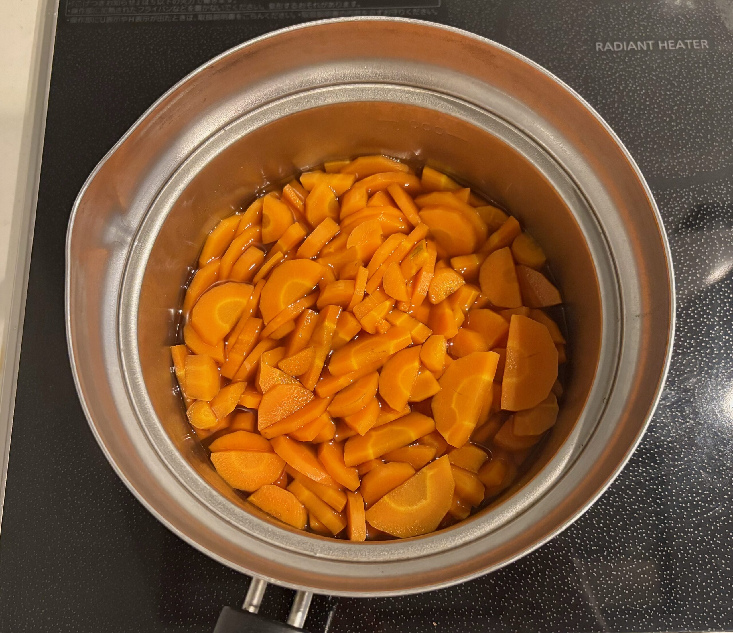 鍋でにんじんを調味料といっしょに煮ているところ