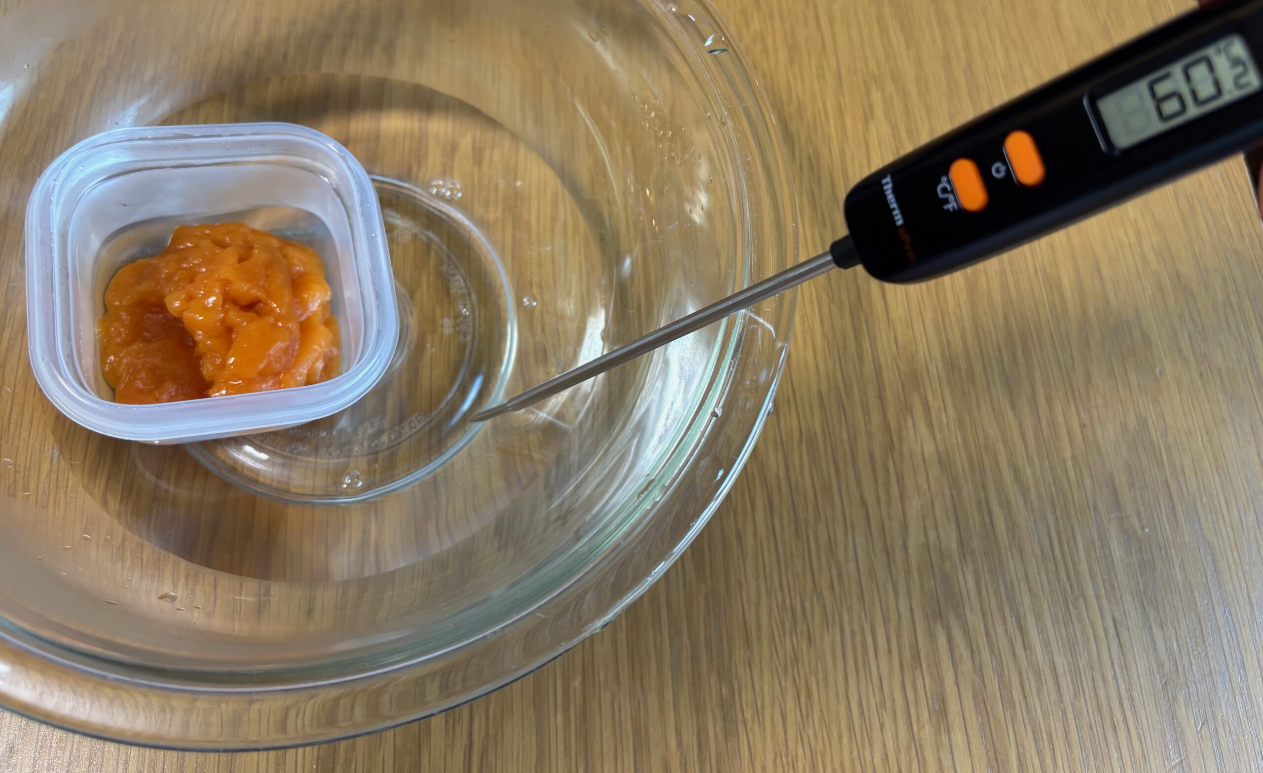 耐熱ボールに入れた60℃のお湯に、保存する容器ごとムース食をつけているところ