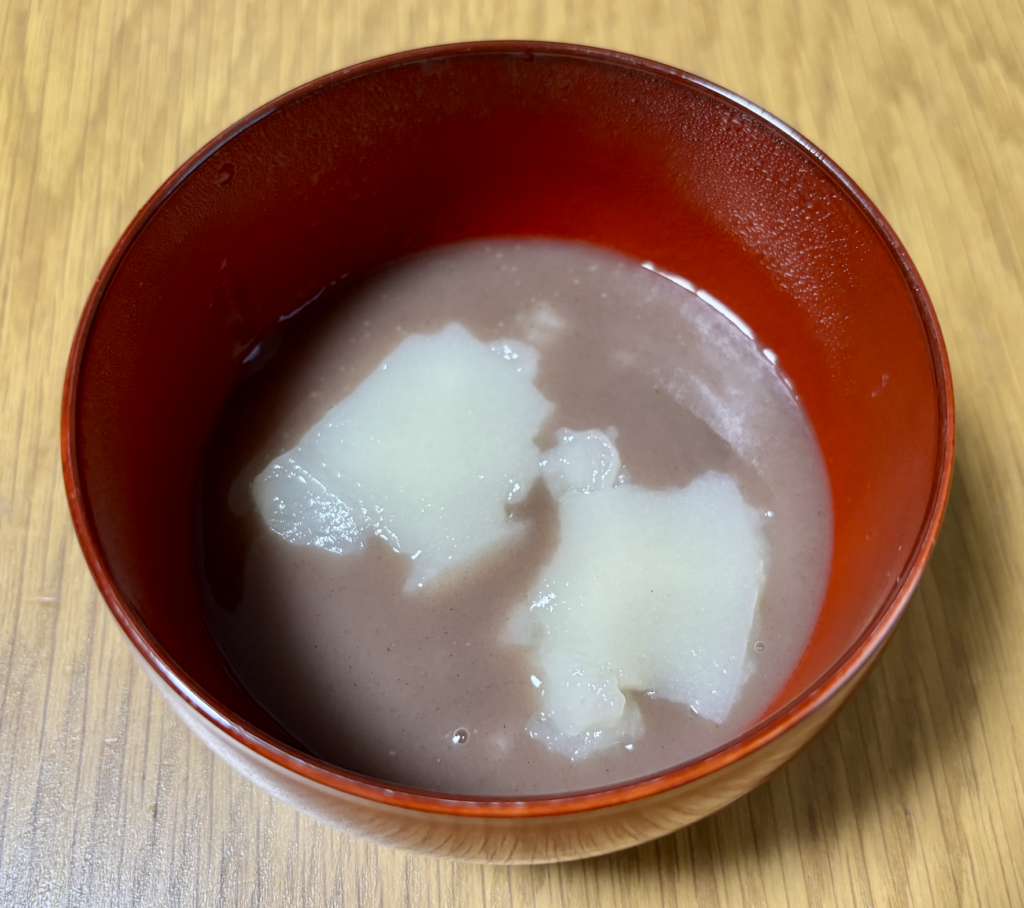 温めたなめらかあずきをかけたスプーンで食べるおもち。嚥下食のお汁粉として器に盛りつけた状態