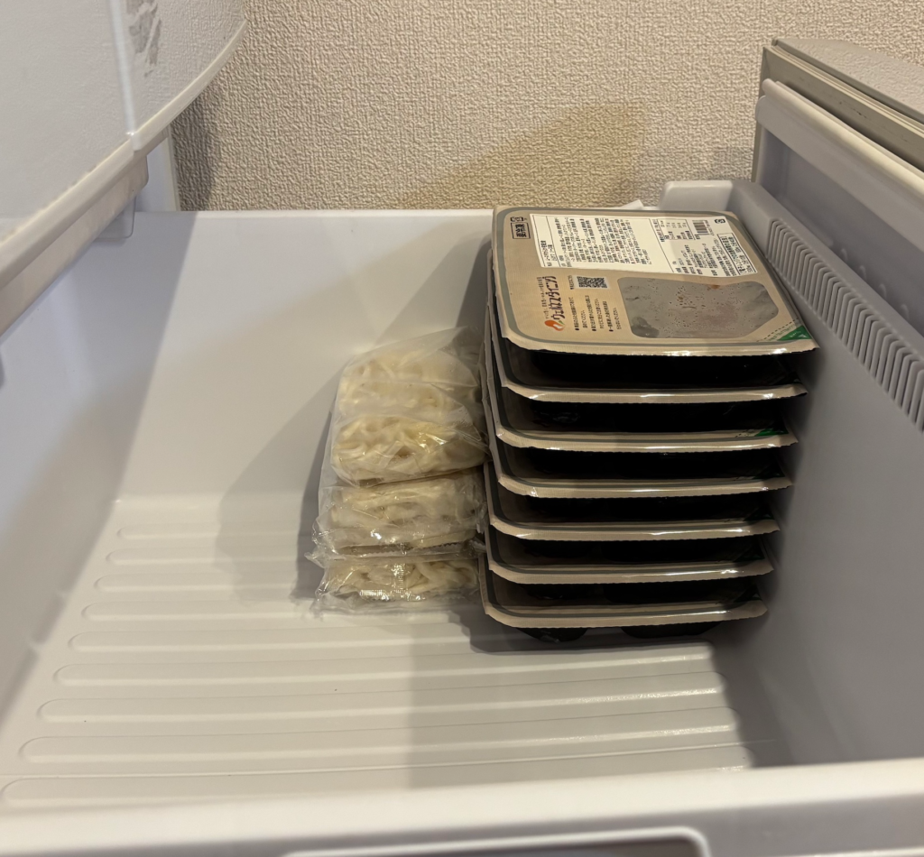 家庭用冷凍庫にウェルネスダイニングのムース食と冷凍うどんを並べて入れた写真