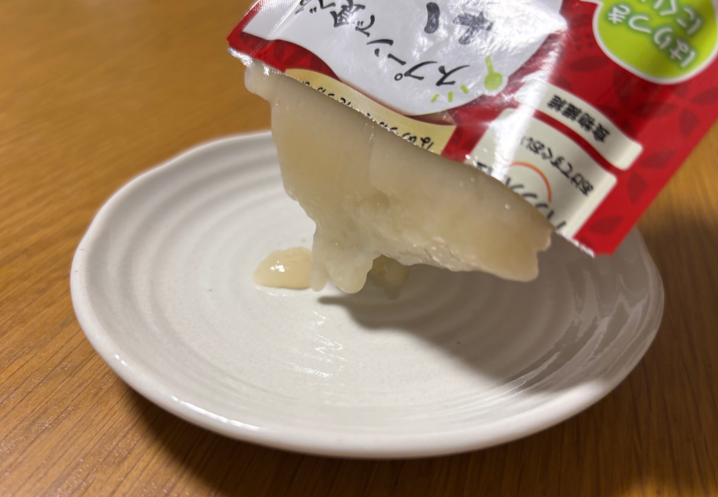 スプーンで食べるおもちをパウチから小皿に押し出しているところ。とろりとやわらかい